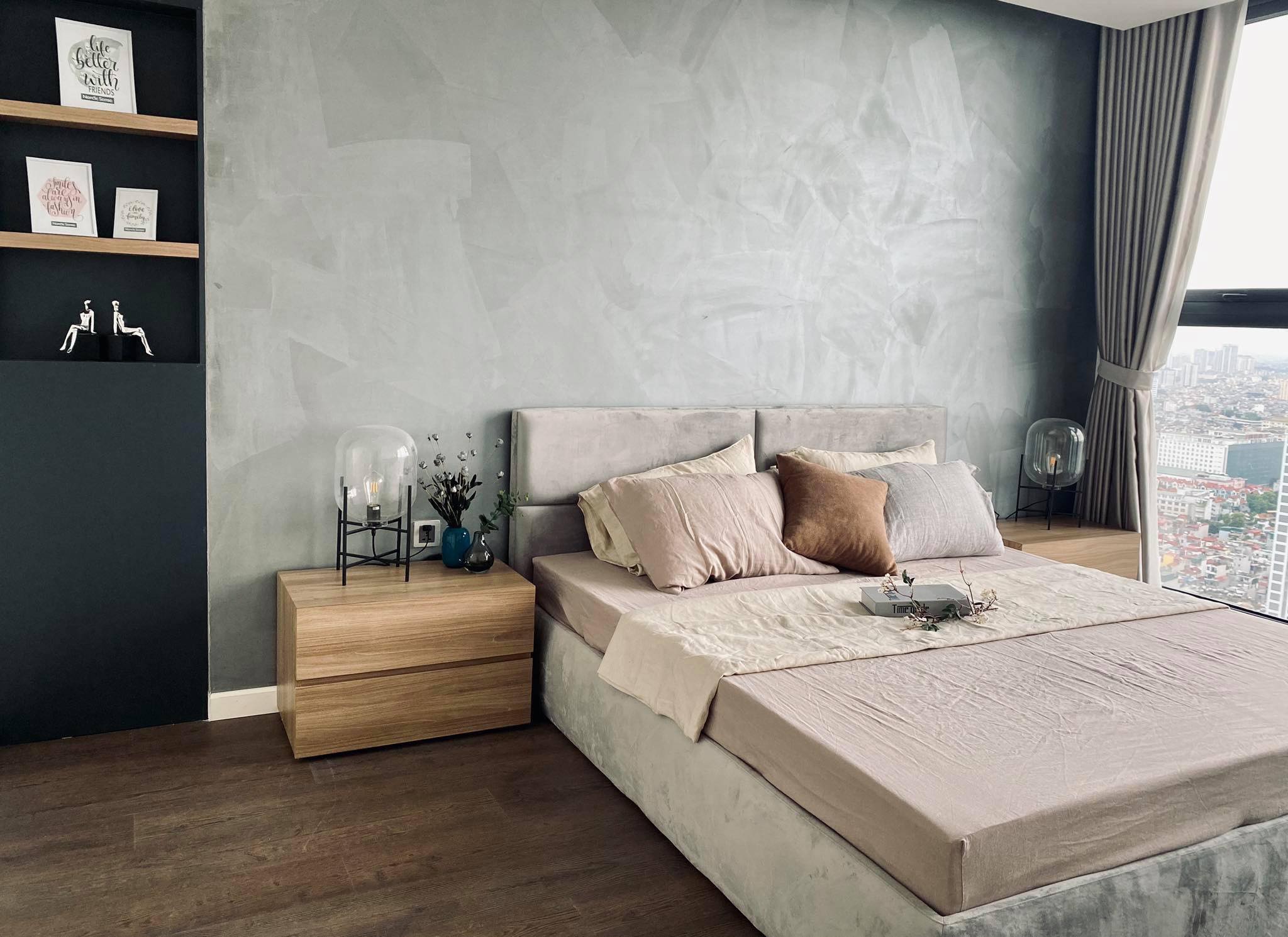 Stone beige SCANDALINEN French linen duvet cover on a high-rise apartment bed with concrete feature wall, city view and warm timber bedside table
