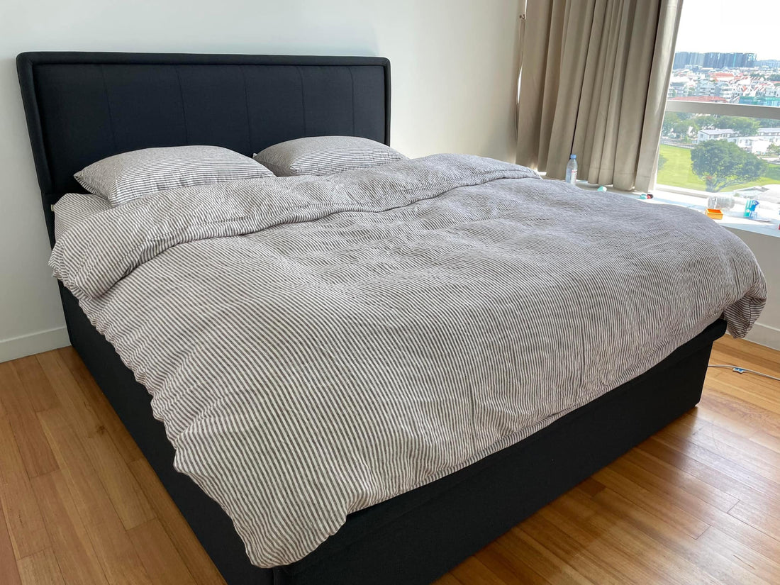 Grey striped yarn-dyed SCANDALINEN French linen duvet cover set on a black upholstered bed in a Singapore apartment with hardwood floors and city view
