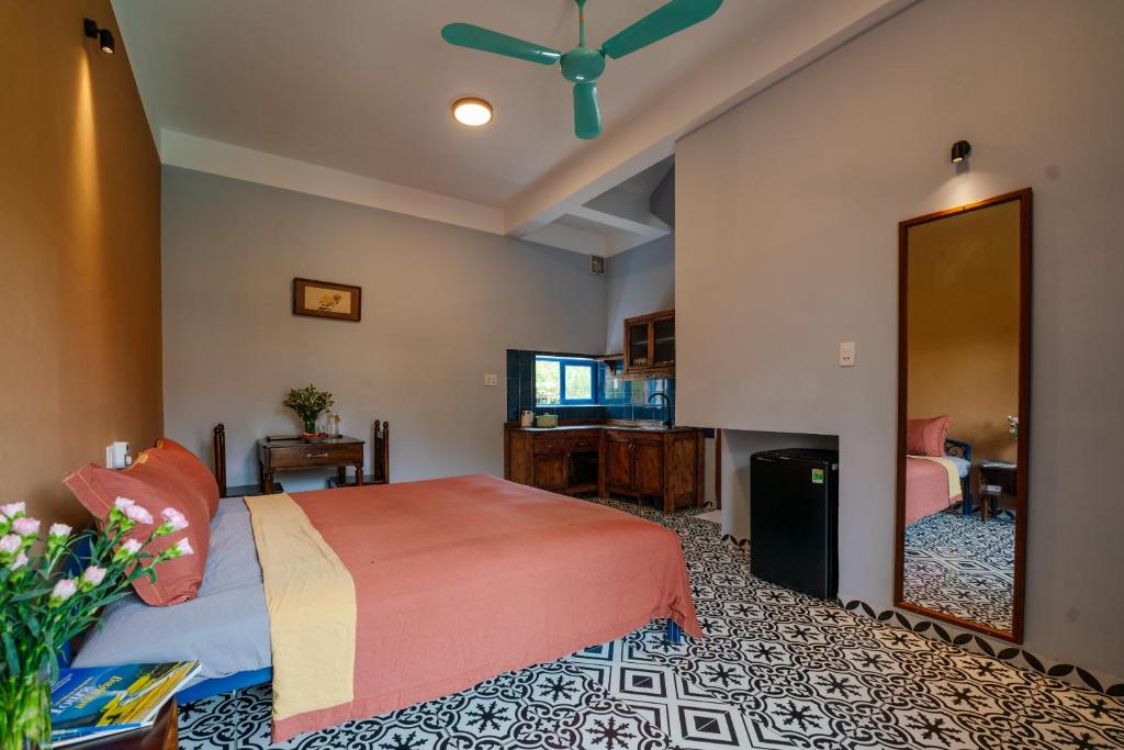 Boutique double room at An Bàng Corner Homestay Hội An with SCANDALINEN terracotta bamboo linen bedding, sage green wall and round mirror