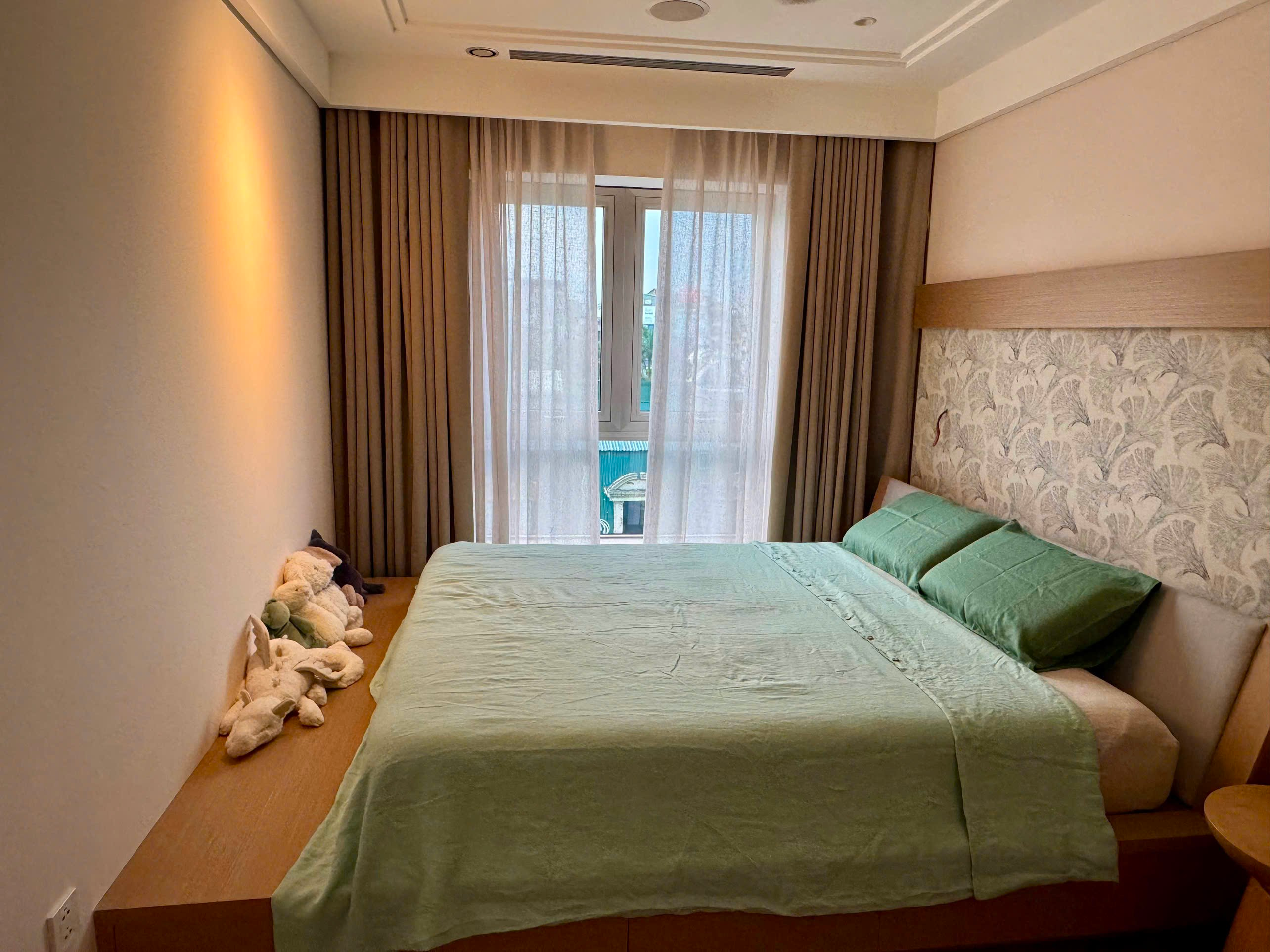 Avocado green French linen duvet cover set styled on a bed in a cozy Hanoi apartment — SCANDALINEN Real Homes