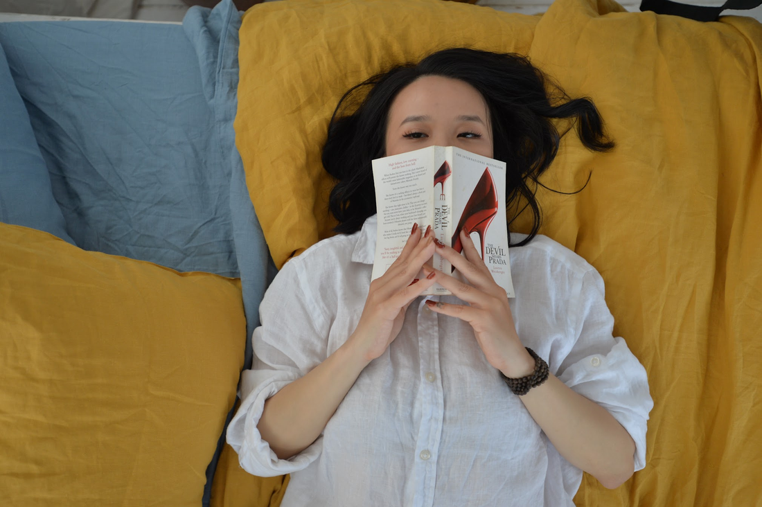 Woman reading in bed on yellow linen bedding – SCANDALINEN