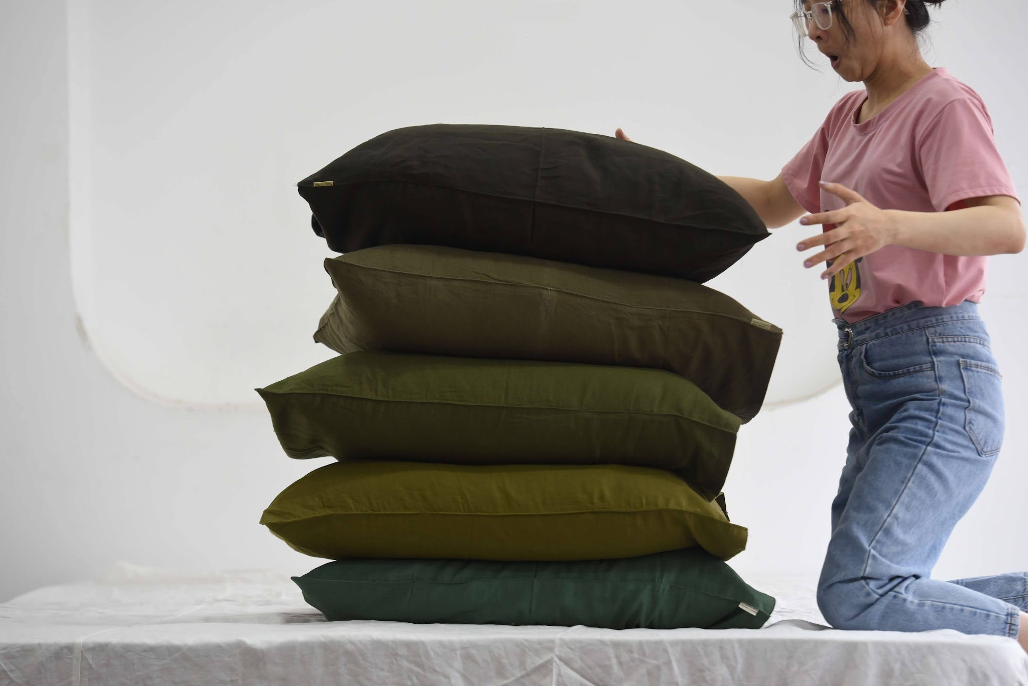 Stack of French linen pillowcases in green tones — SCANDALINEN size guide for Australia