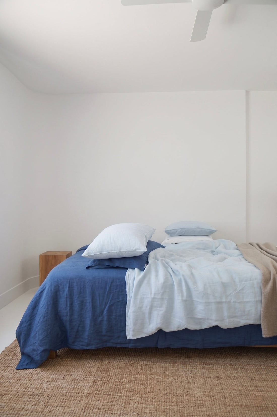 SCANDALINEN blue linen bedding on a bed with white pillows, styled in a minimal bedroom