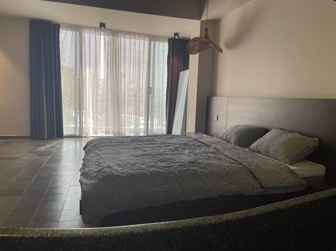 Charcoal SCANDALINEN French linen bedding in a modern minimalist bedroom with large windows