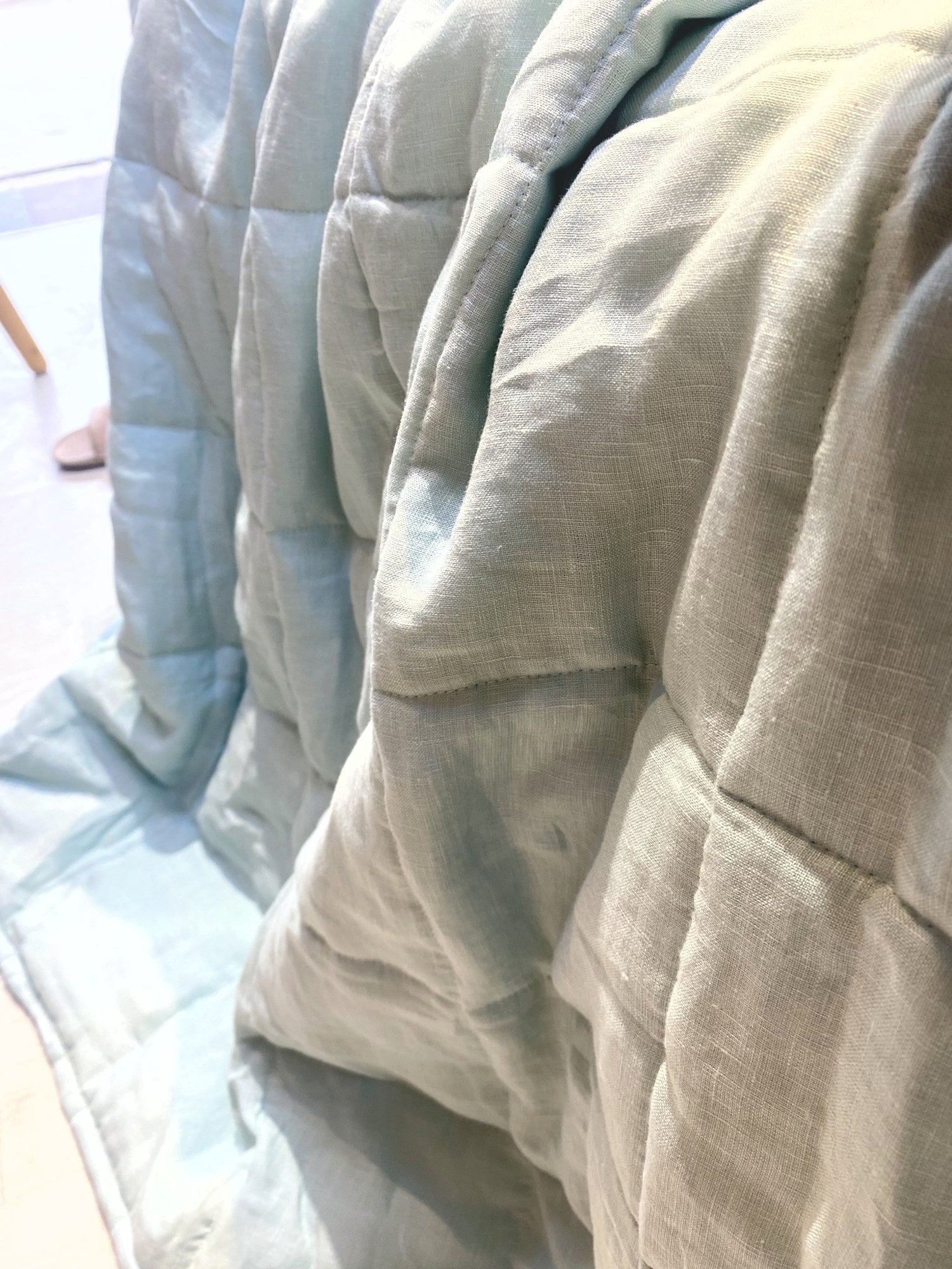 Eucalyptus Sage French linen quilted blanket on a bed, 100% European flax, stonewashed - SCANDALINEN