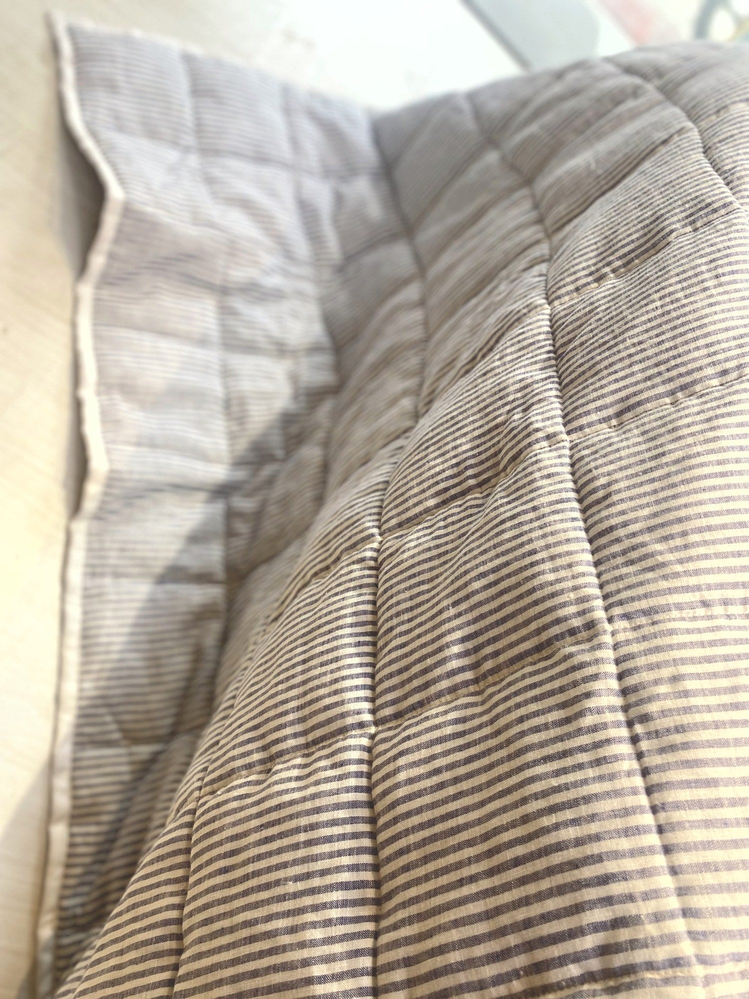 Mushroom taupe French linen quilted blanket on a bed, 100% European flax - SCANDALINEN