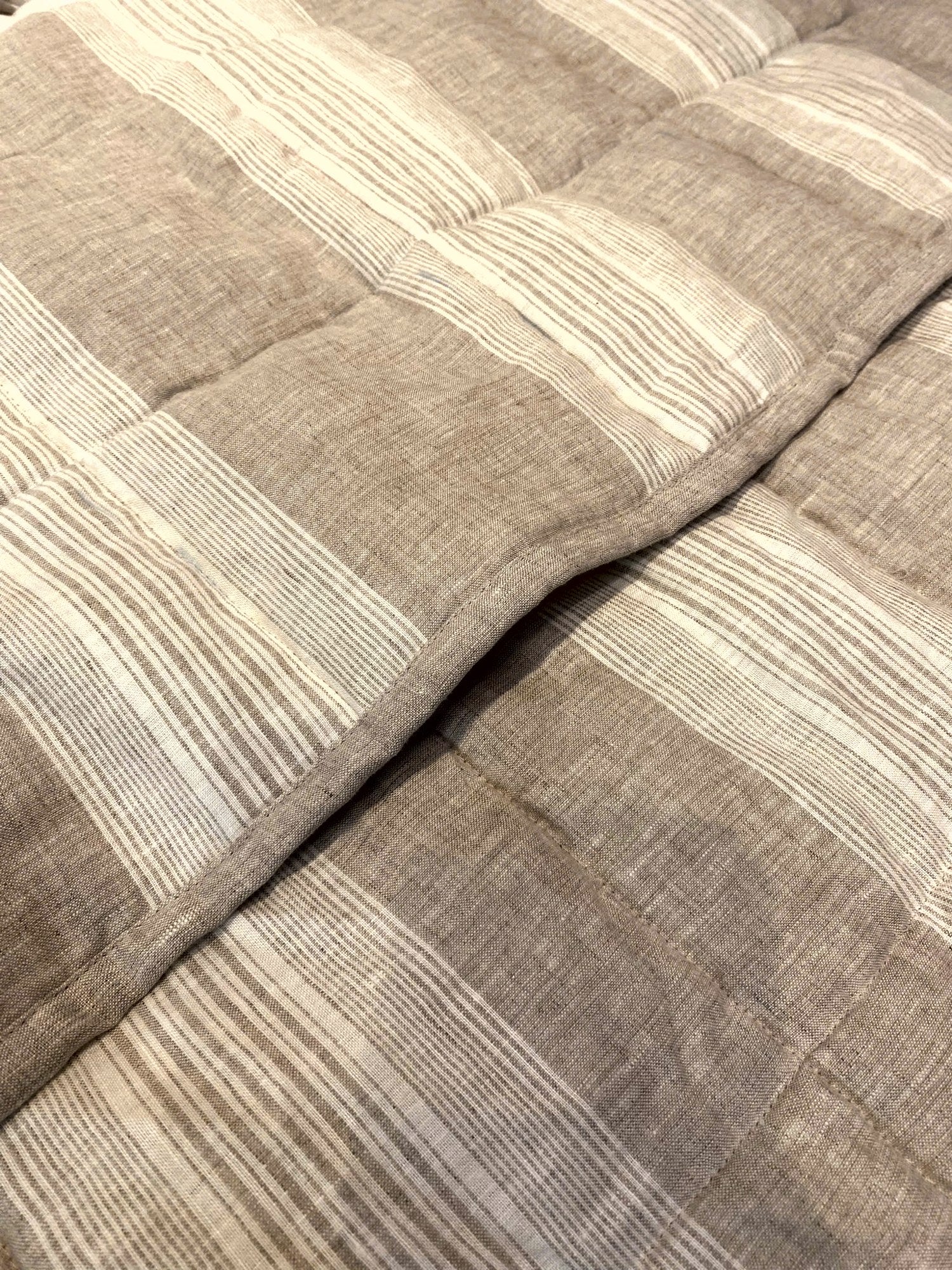 Natural oat stripe French linen quilted blanket on a bed, 100% European flax - SCANDALINEN