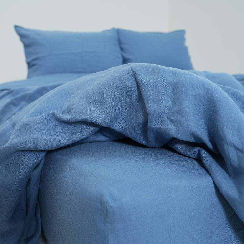 Denim blue French linen flat sheet on a bed, 100% European flax, stonewashed - SCANDALINEN