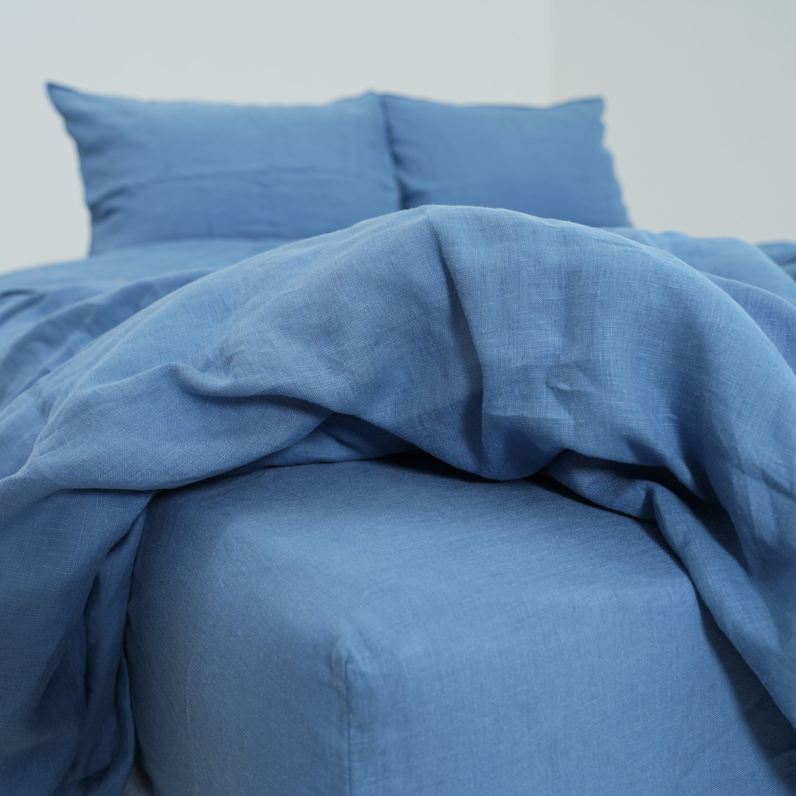 Denim blue French linen flat sheet on a bed, 100% European flax, stonewashed - SCANDALINEN