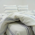 Ivory and navy striped French linen flat sheet on a bed, 100% European flax, stonewashed - SCANDALINEN